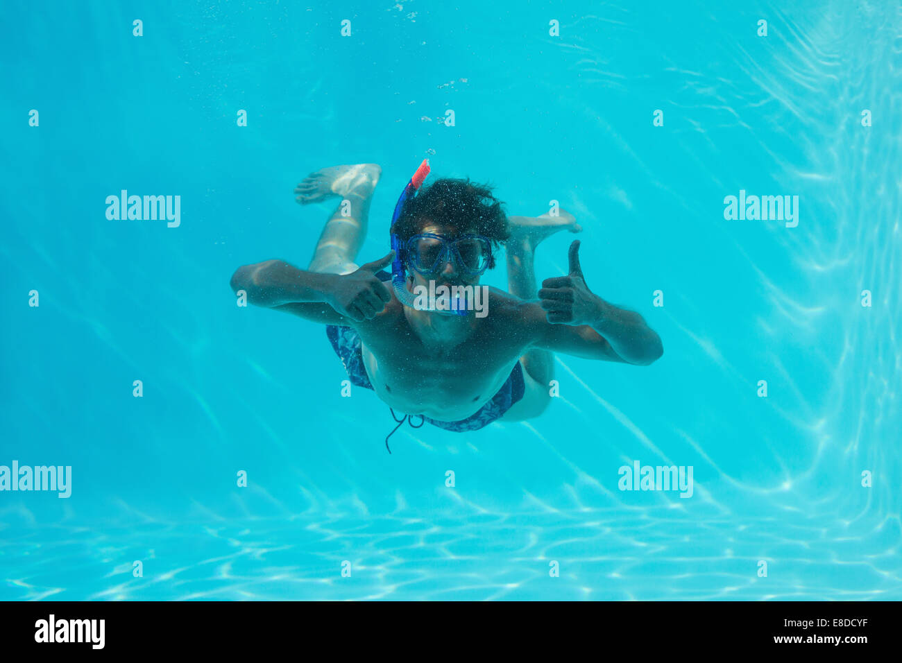 L'uomo underwater gesticolando pollice in alto Foto Stock