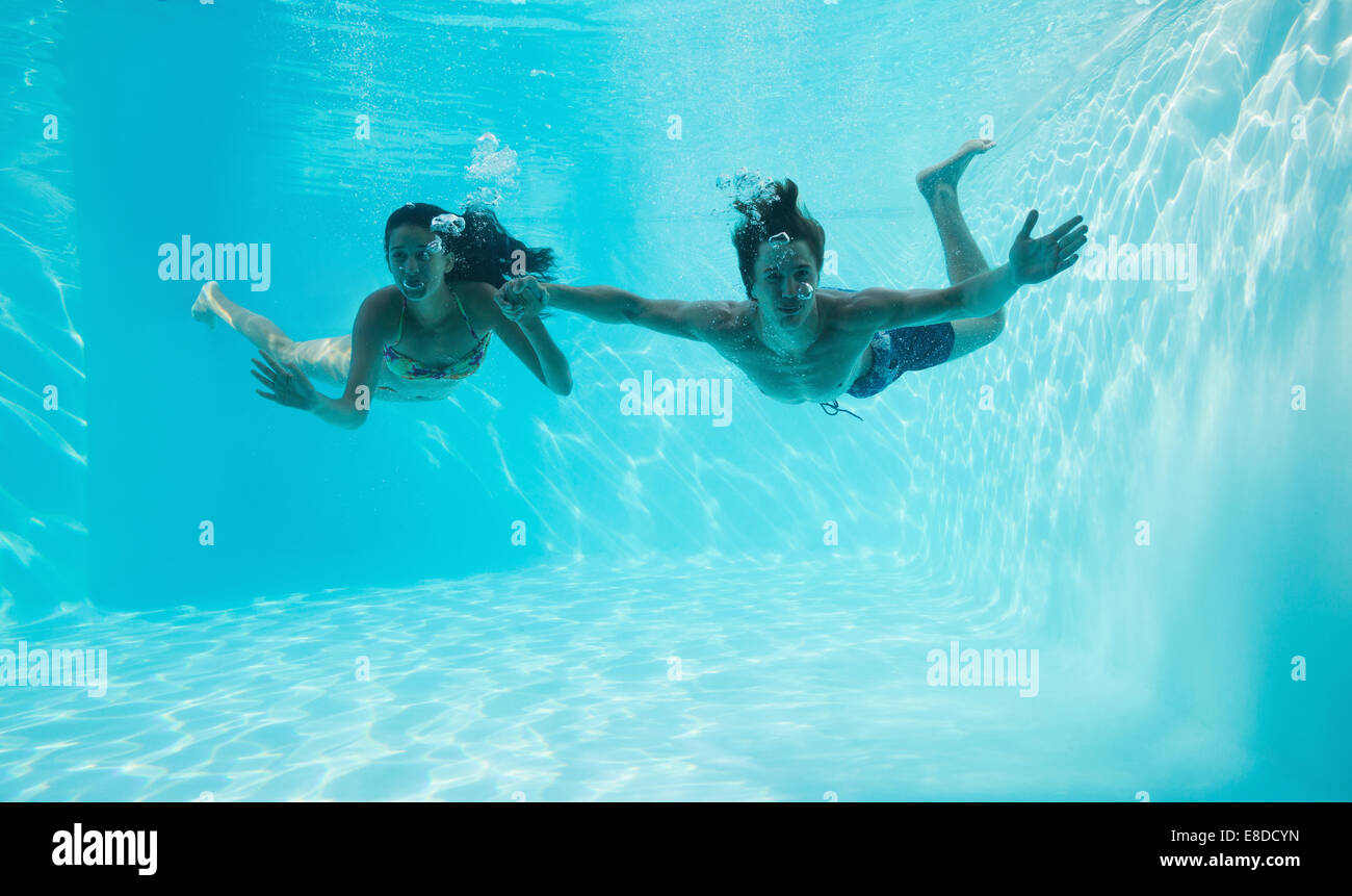 Giovane tenendo le mani e nuotare sott'acqua Foto Stock