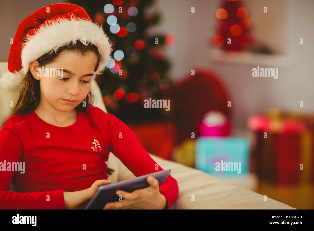 Festive bambina utilizzando tablet pc sul lettino Foto Stock