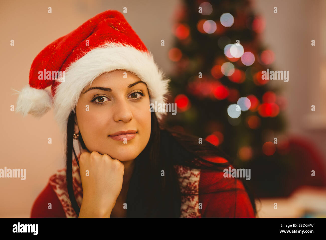 Festive brunette indossando un cappello da Babbo Natale Foto Stock