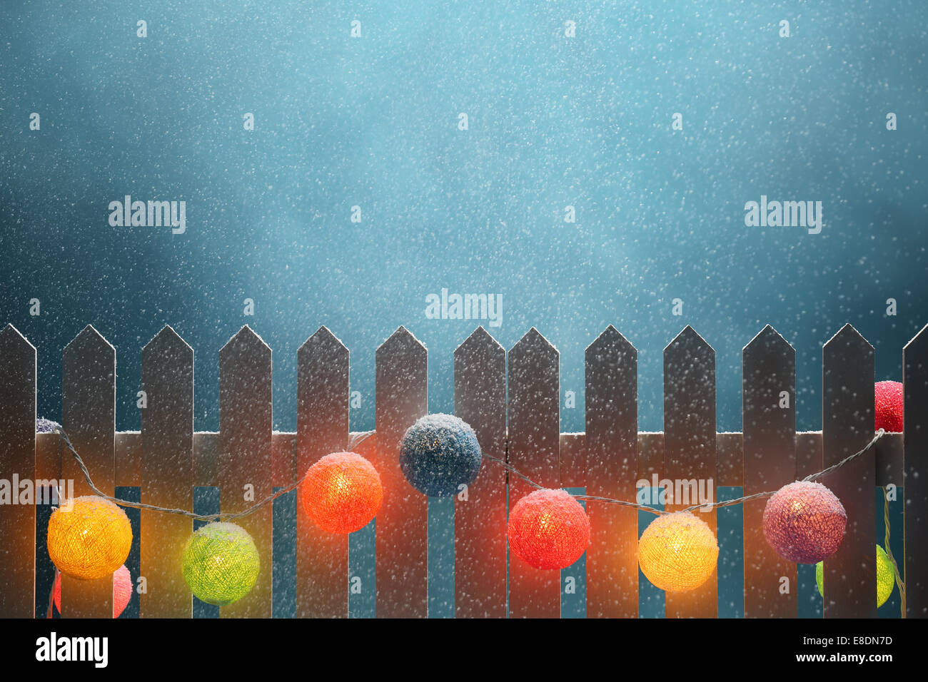 Pallina di natale luci appeso alla recinzione al notte nevosa Foto Stock