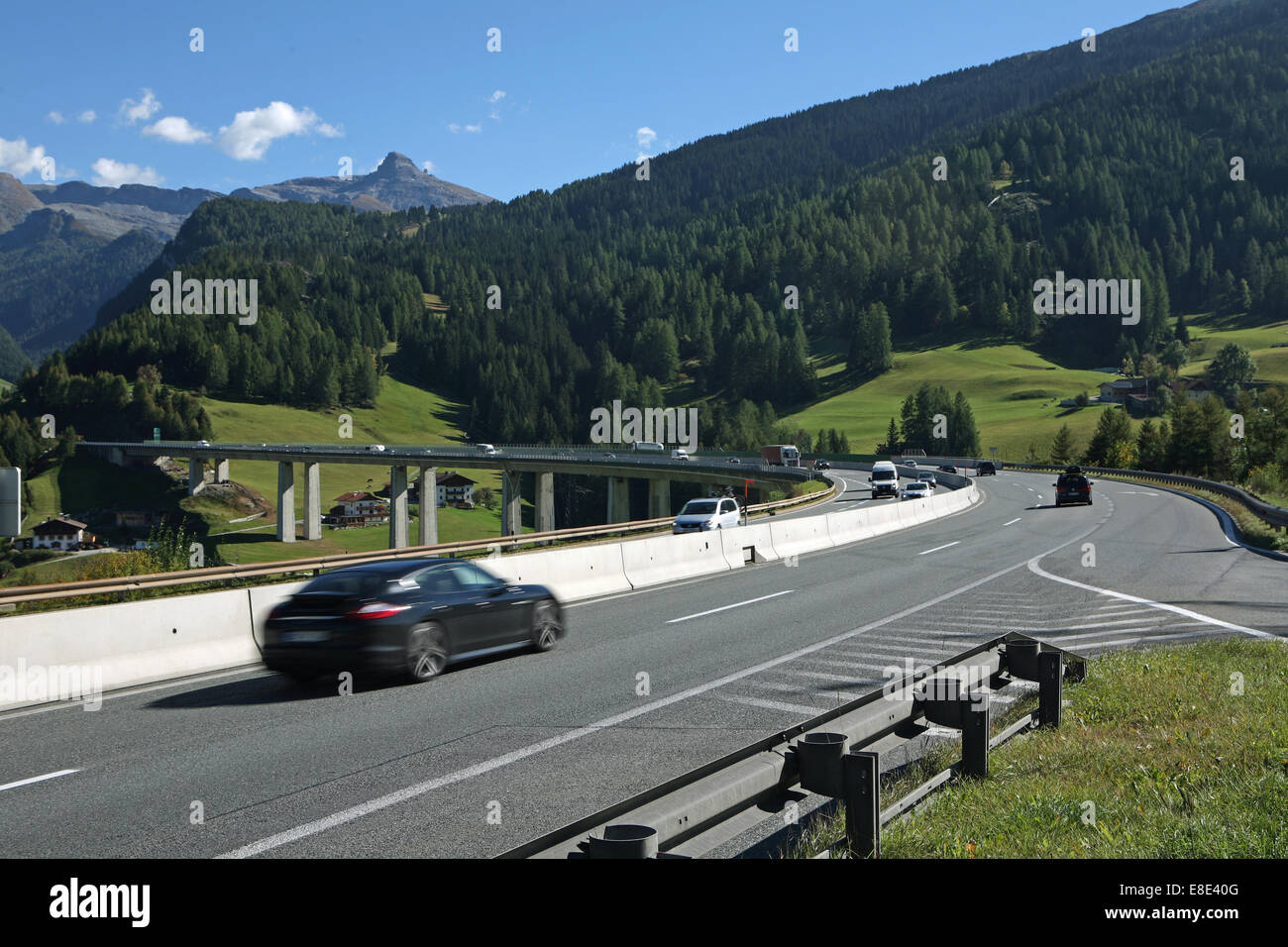 Austrian Autobahn autostrada con il cavalcavia di ponte di montagne boscose giornata di sole Foto Stock