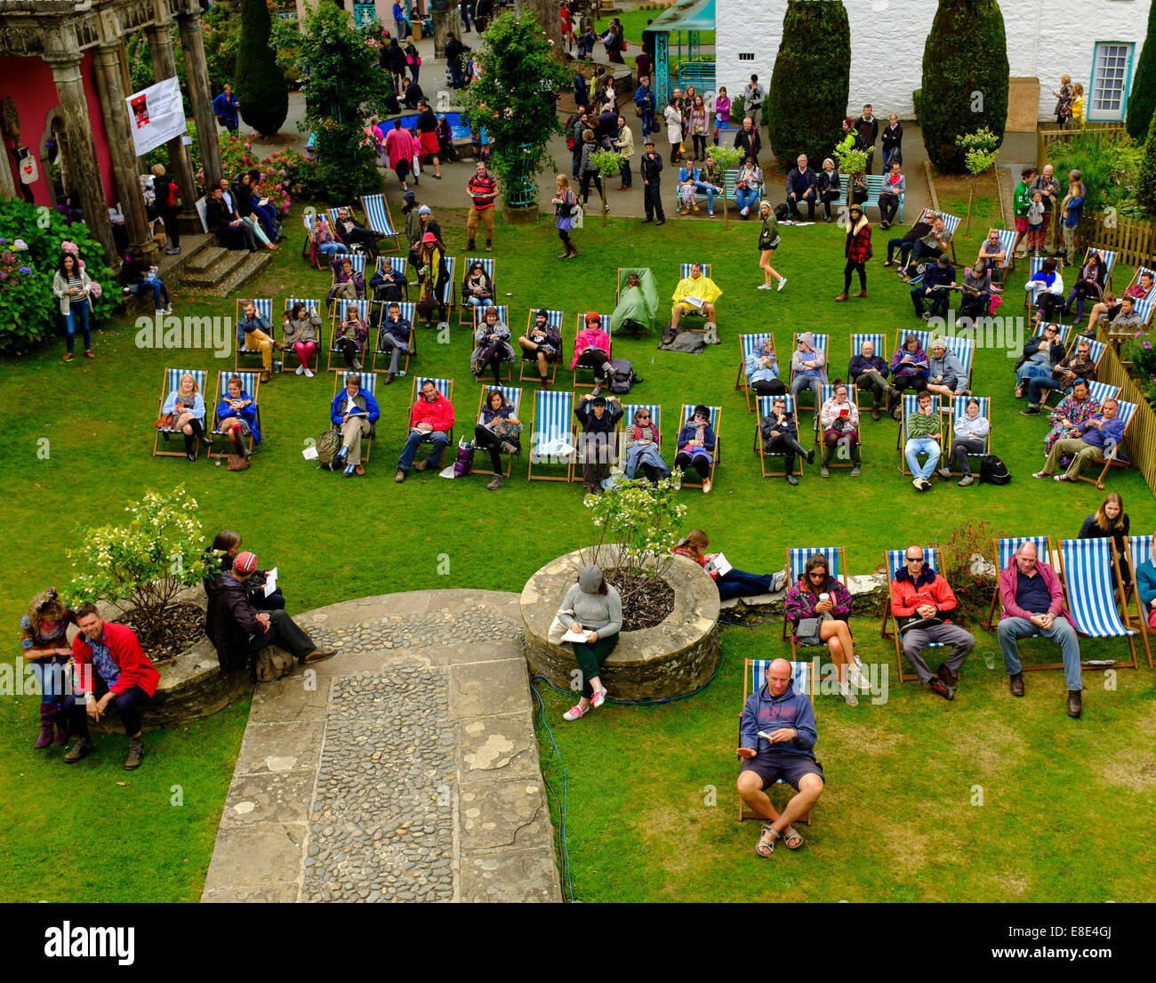 Persone sedute in attesa di una prestazione in piazza. 'Festival No.6'. 6 Settembre 2014 a Portmeirion, Galles del Nord, Regno Unito. Foto Stock
