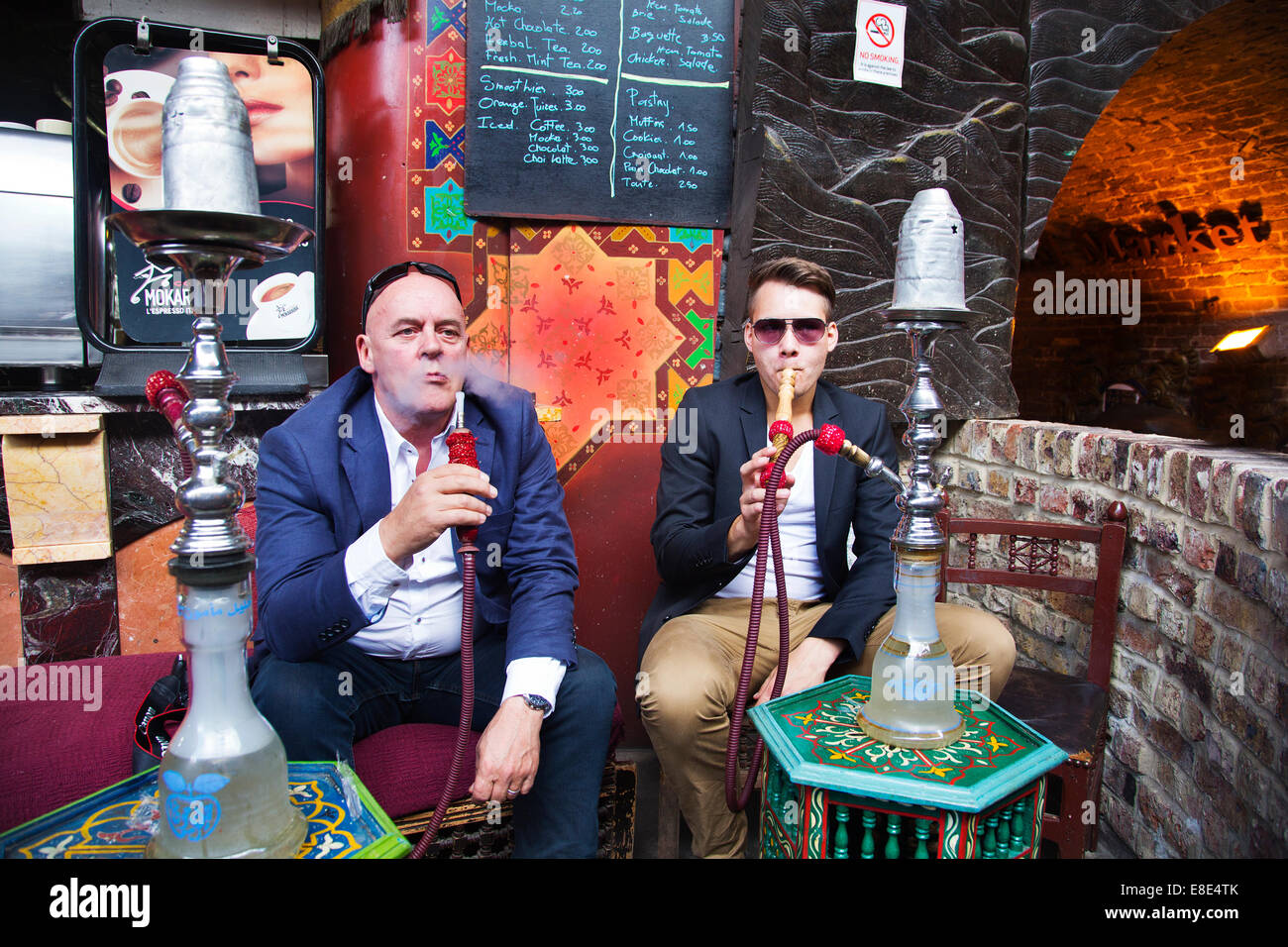 I fumatori ad un shisha cafe nelle scuderie mercato, Camden, a nord di Londra. Foto Stock