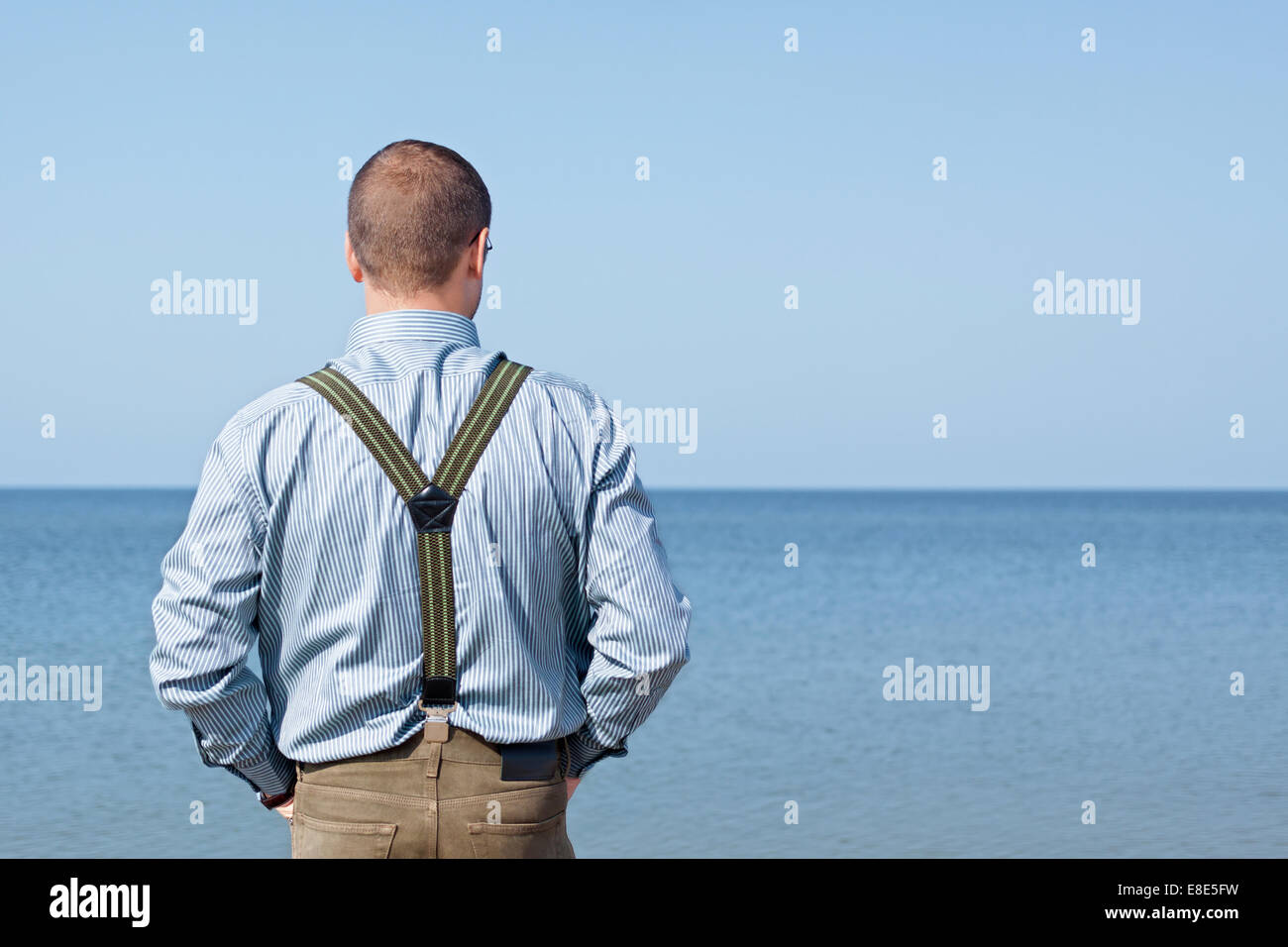 Uomo di 40 anni in piedi indietro guardando il mare Foto Stock