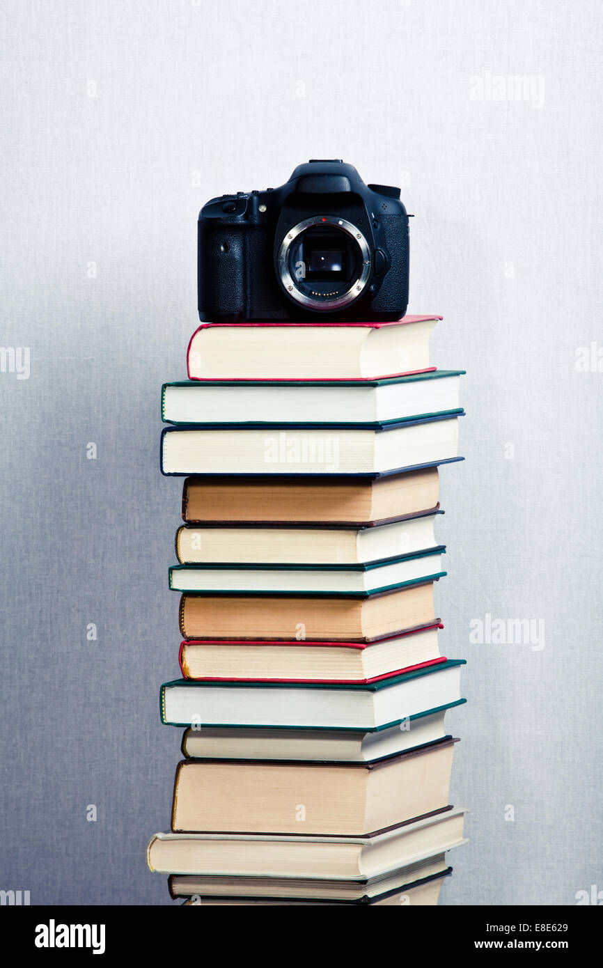 Immagine fotocamera su un alta pila di libri Foto Stock