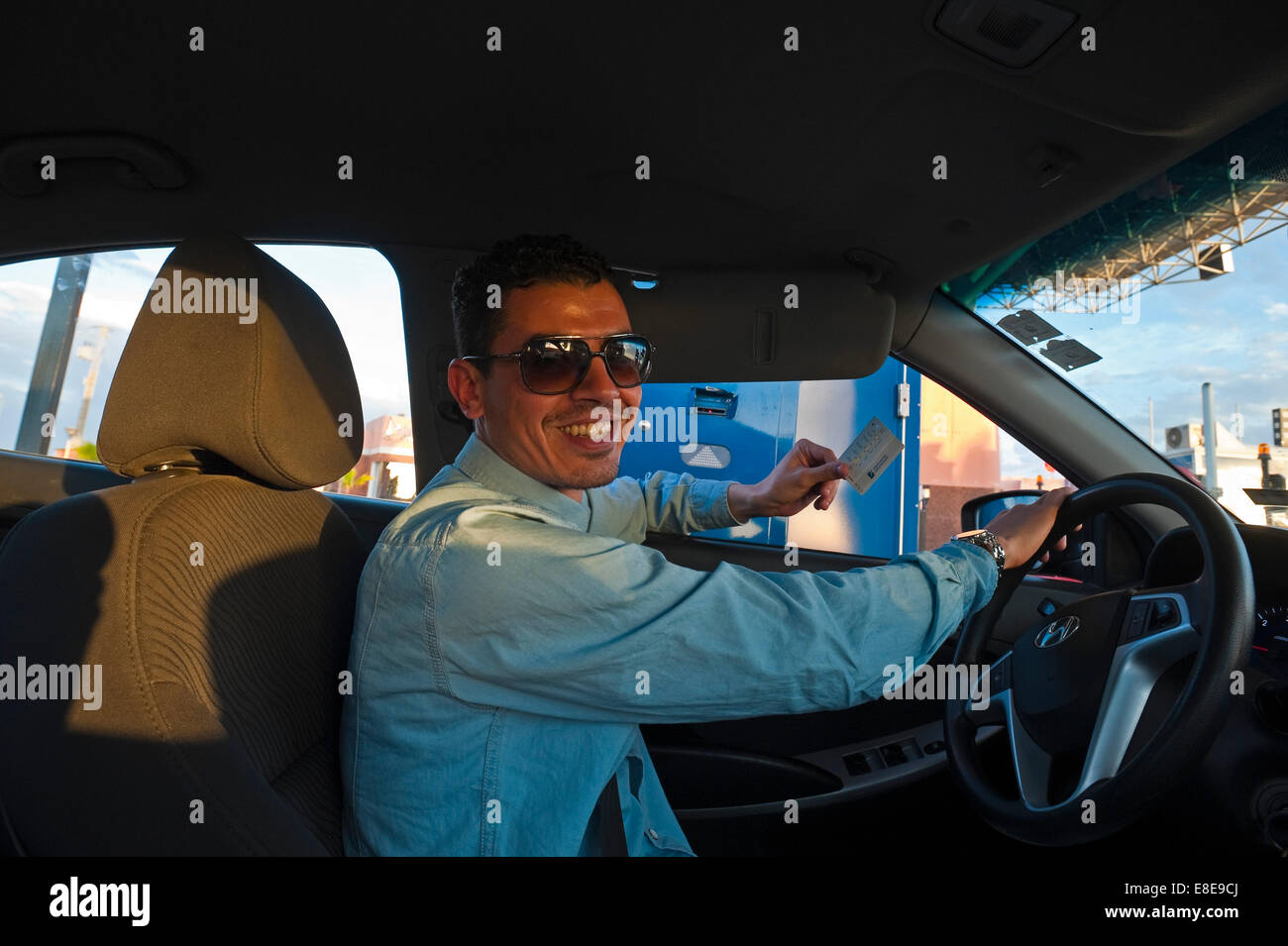 Ritratto orizzontale di un giovane marocchino uomo alla guida di una guida a sinistra sulla vettura del nuovo A7 autostrada. Foto Stock