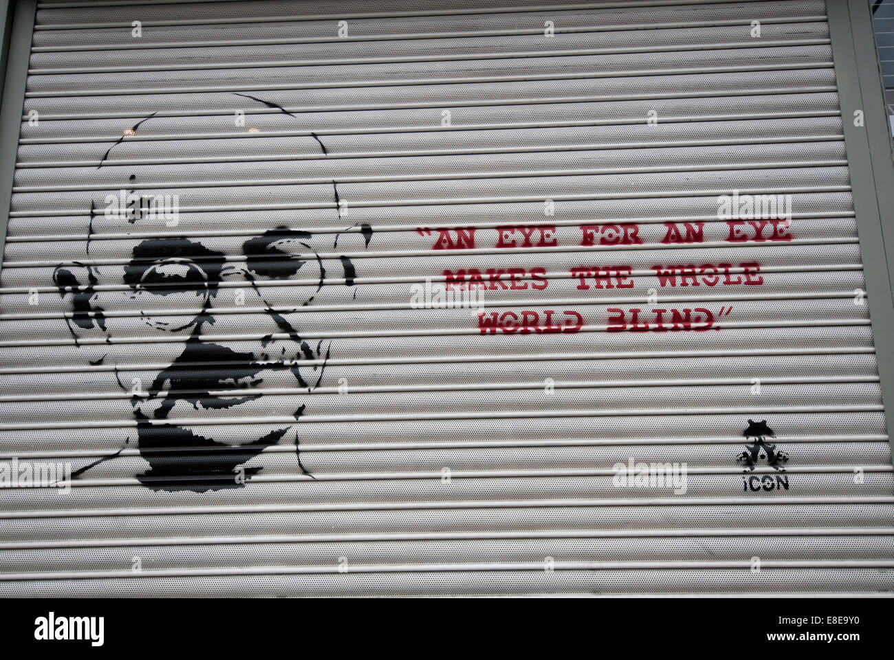 Citazione da Gandhi "occhio per occhio rende cieco il mondo intero' graffitied sulla parete Foto Stock