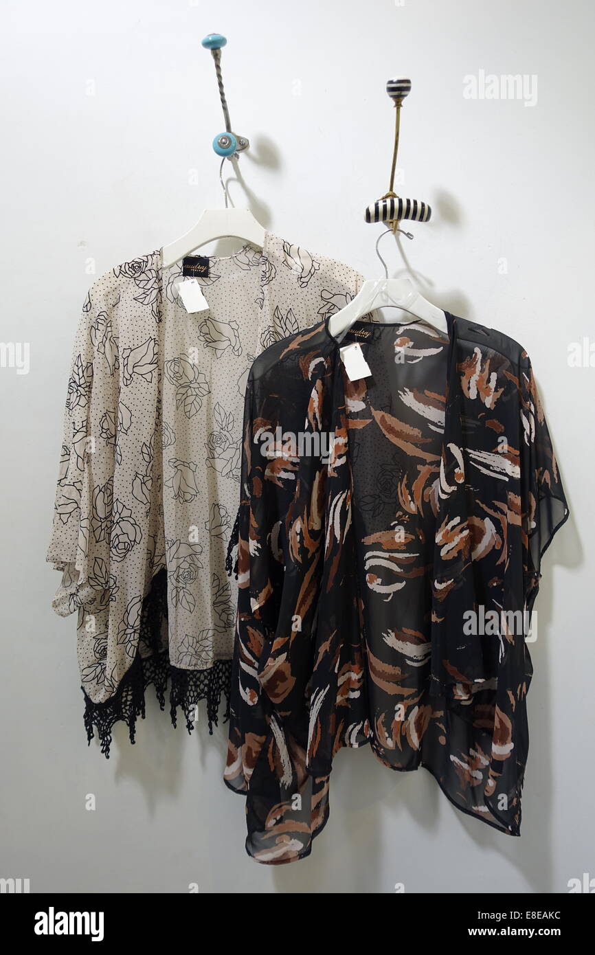 Due annebbiato kimono tops appeso su pioli in una lady's spogliatoio, pronto per essere provato su. Oklahoma, Stati Uniti d'America Foto Stock