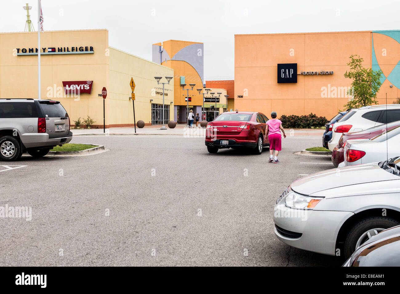 Outlet Shoppes a Oklahoma City, Oklahoma, Stati Uniti d'America un factory outlet mall, mostrando gli amanti dello shopping a piedi verso il centro commerciale dal parcheggio. Foto Stock