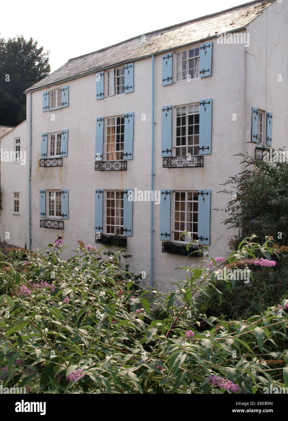 A tre piani di casa con persiane blu su windows, Lyme Regis, Dorset, Regno Unito Foto Stock