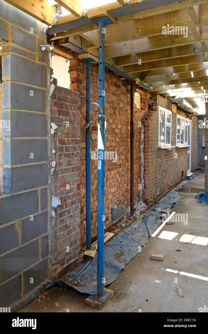 Casa lavoro di estensione Acrow puntelli di supporto in acciaio strutturale e pavimento in legno travetti esistenti accanto al muro di mattoni Essex England Regno Unito vedere 'More Info' nota di seguito Foto Stock