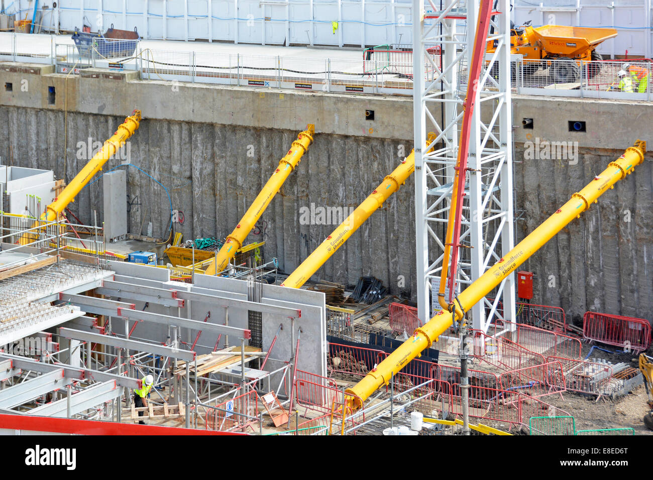 Esposti impilati a parete di ritegno temporaneo e giallo puntoni idraulico al posto intorno al perimetro del seminterrato lavori di fondazione Londra Inghilterra REGNO UNITO Foto Stock