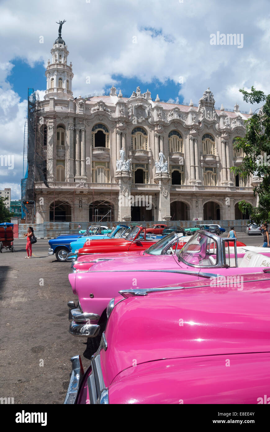 I turisti possono prendere il loro pick vintage American automobili a noleggio parcheggiato in una strada appena adiacente al Grand Theatre di La Habana Foto Stock
