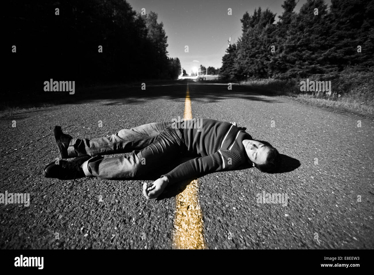 Strada vuota con corpo morto nel mezzo di notte Foto Stock