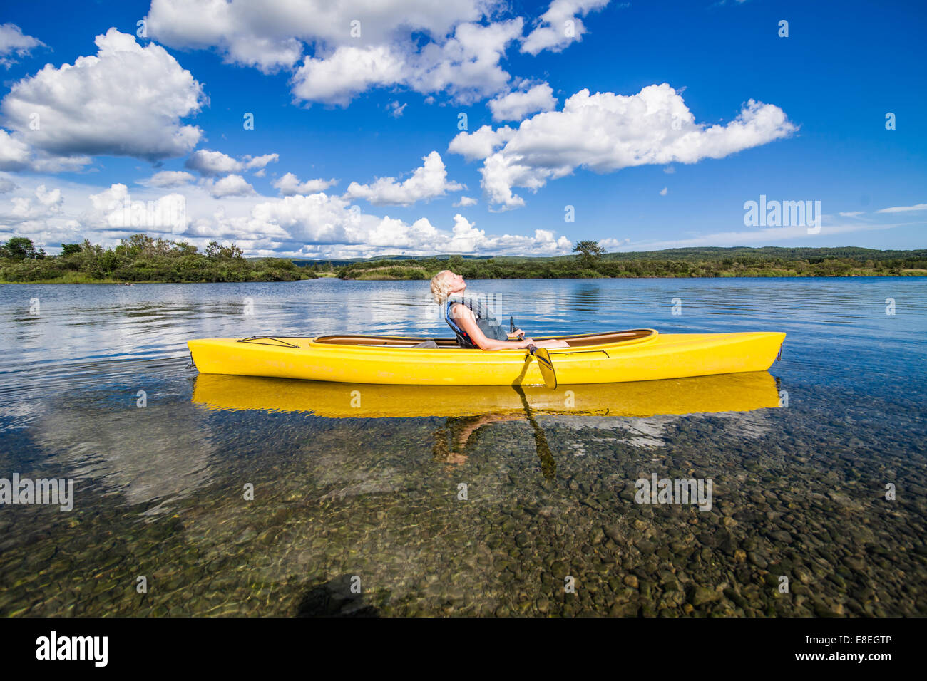 Donna rilassante su giallo kayak in natura Foto Stock
