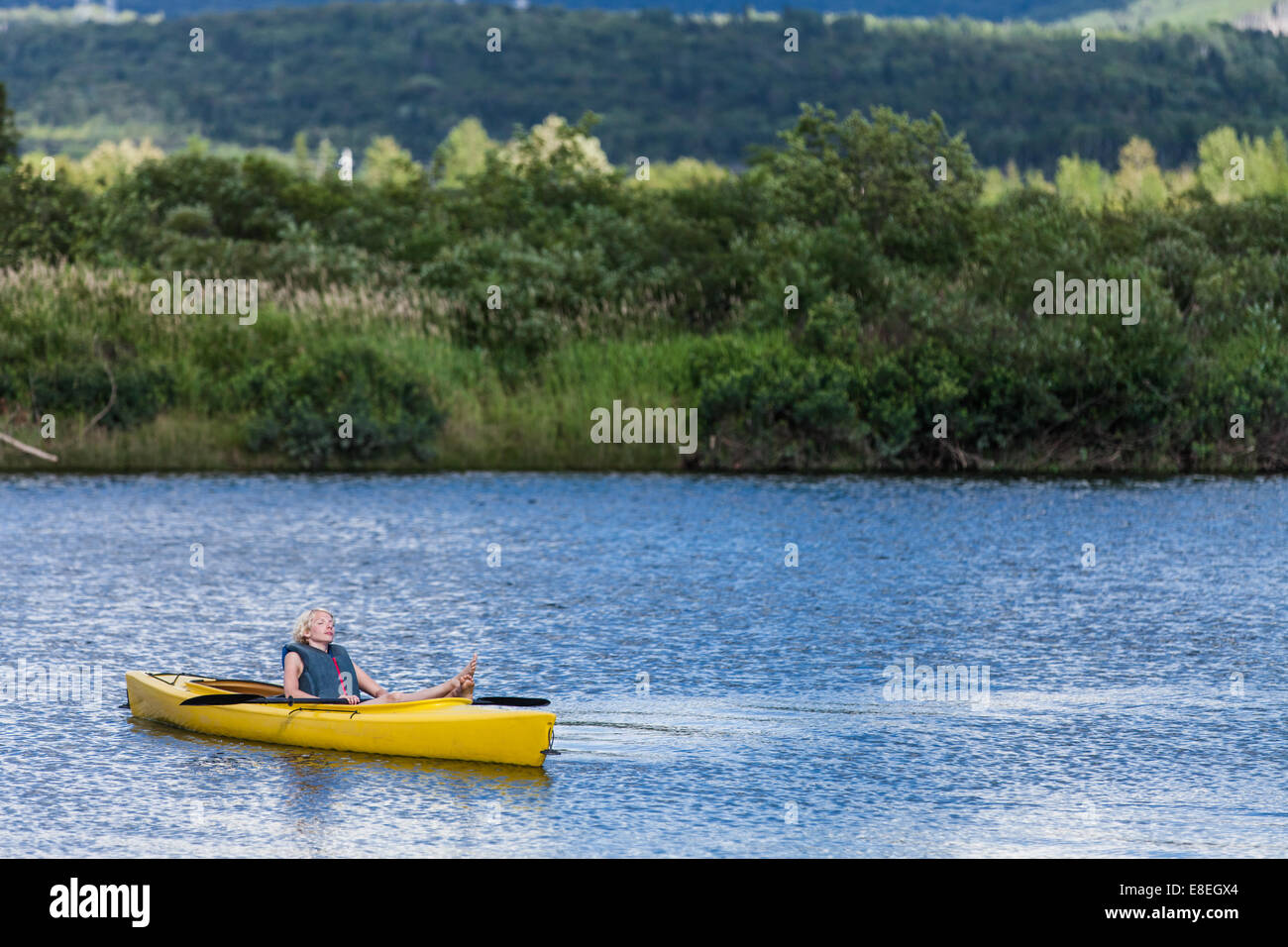 Fiume calmo e rilassante donna in un kayak giallo Foto Stock