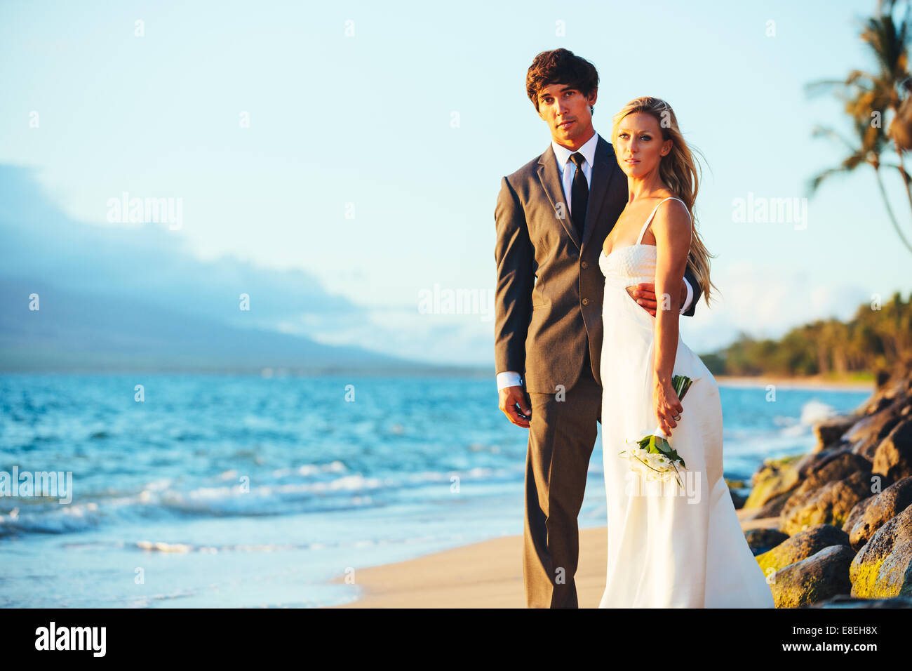 Bella coppia di nozze sulla spiaggia al tramonto Foto Stock