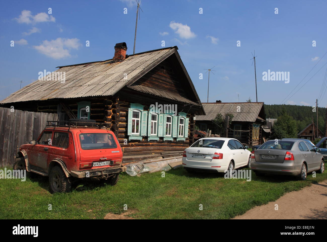 Domestico privato e importazione di automobili parcheggiate vicino alla vecchia casa di registro nel villaggio di Serbishino nei monti Urali vicino a Ekaterinburg 2014 Foto Stock