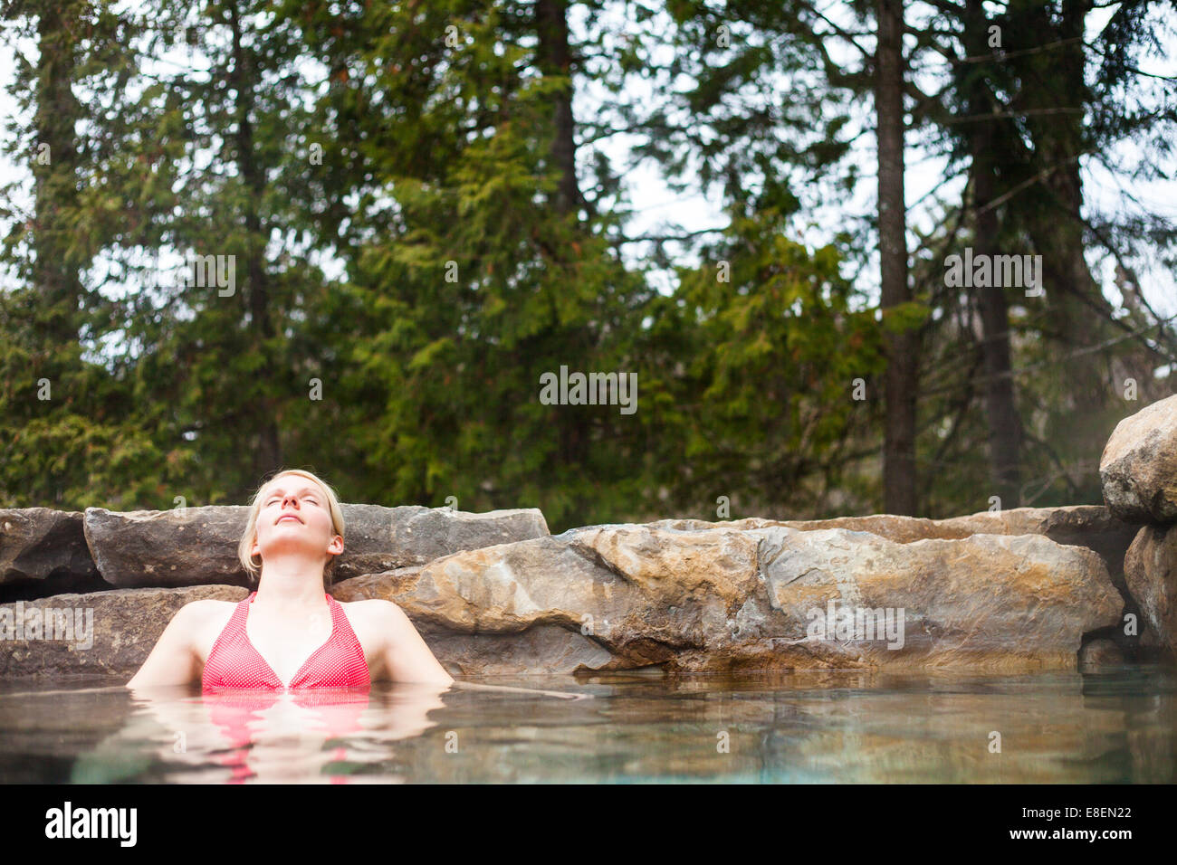 Giovane donna rilassante in un Outdoor Nordic Spa, nella foresta. Foto Stock