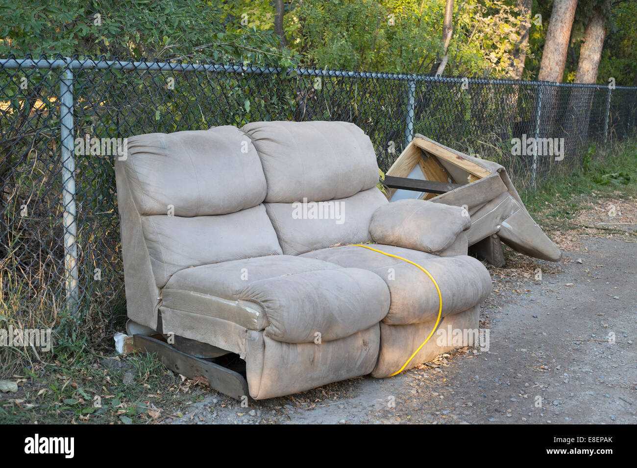 Il divano rotto scartato e scaricato in un vicolo posteriore. Foto Stock