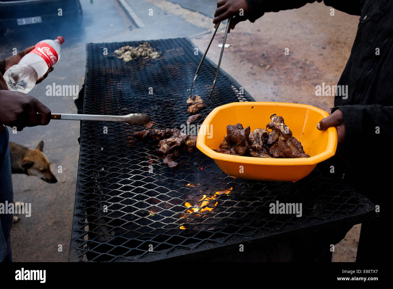 Gli uomini preparare costolette di montone su un incendio per un client in un Makhaza taxi. La posizione centrale lo rende famoso per i ristoranti. Foto Stock
