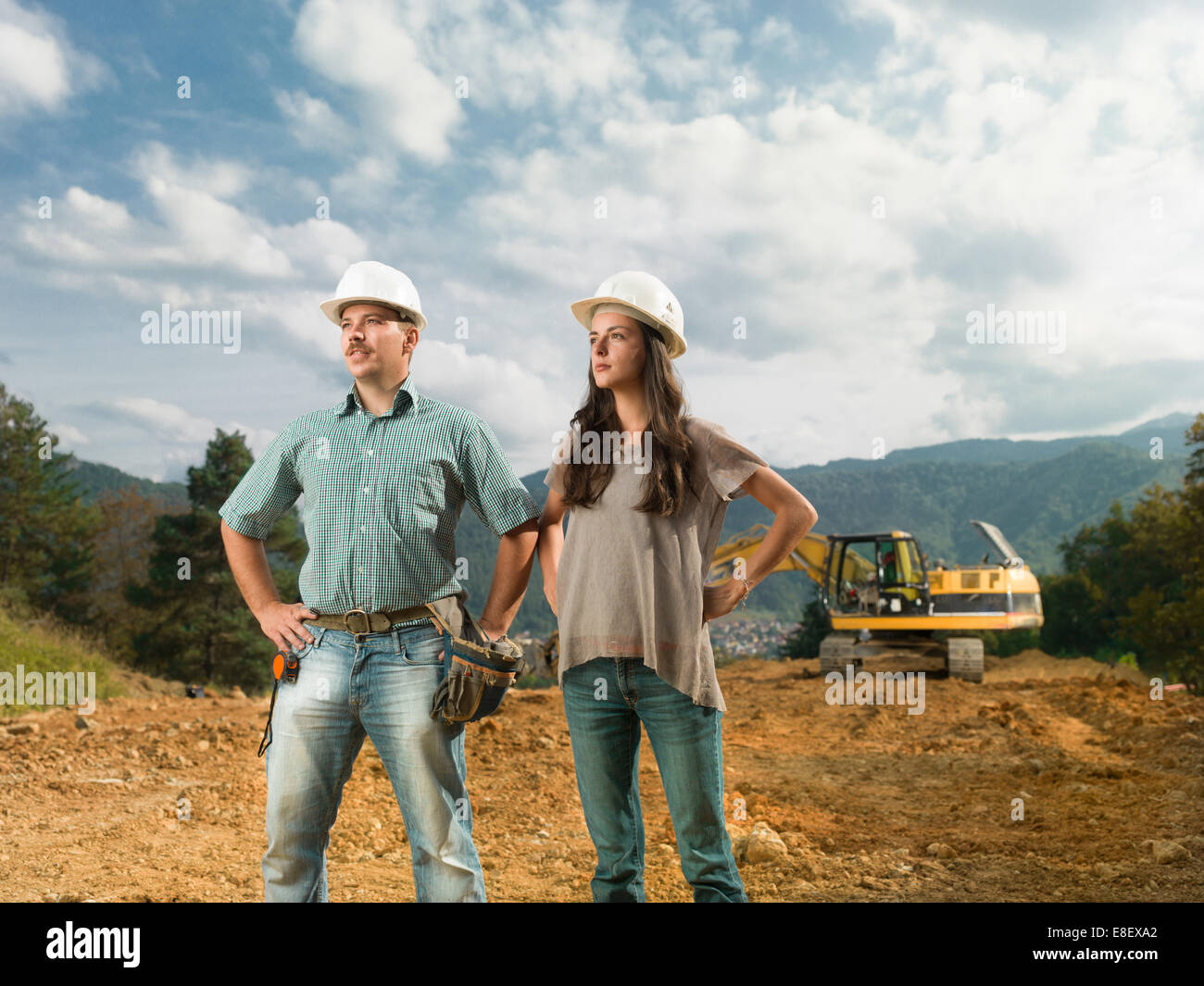 Maschi e femmine di colleghi ingegneri permanente sulla costruzione sito alla ricerca di distanza Foto Stock