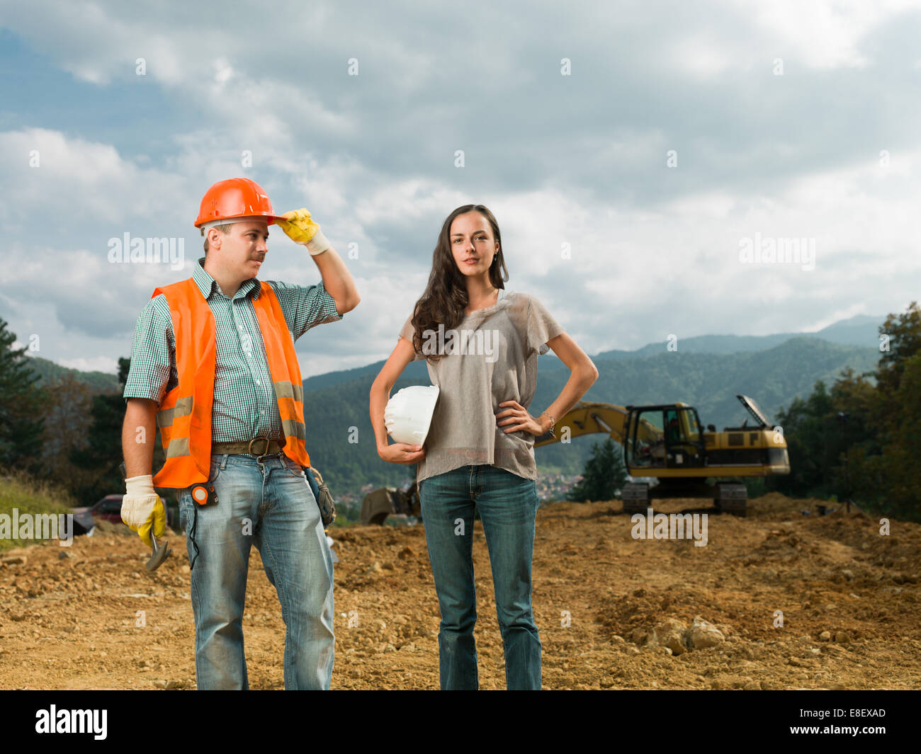 Maschio e femmina di ingegneri in piedi sul sito in costruzione all'aperto Foto Stock
