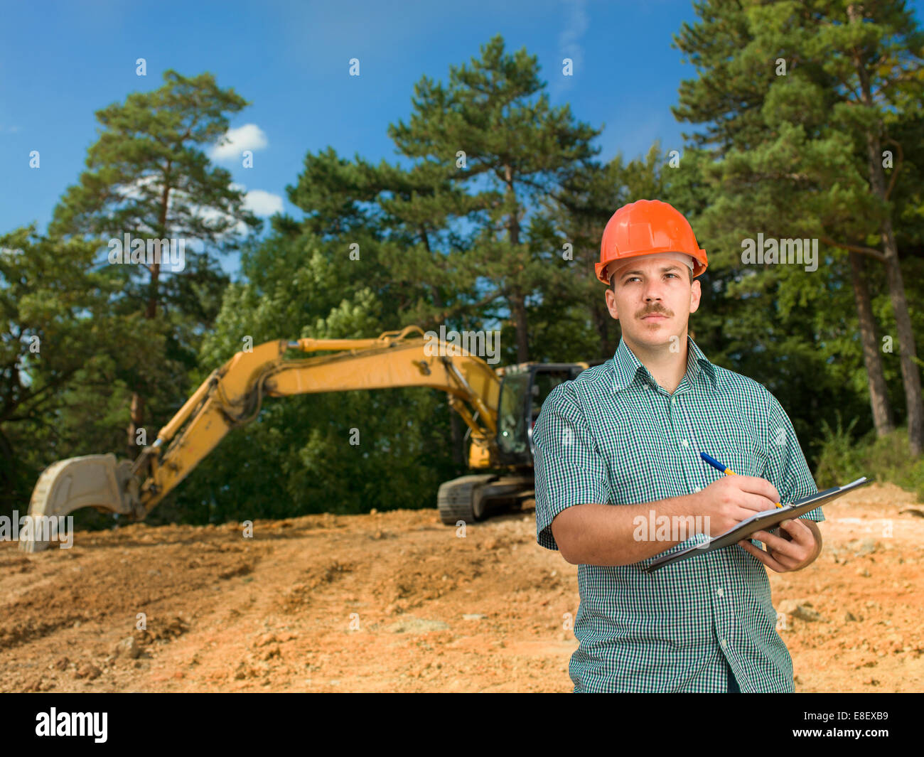 Maschio caucasico architetto prendendo appunti su appunti nel sito in costruzione Foto Stock