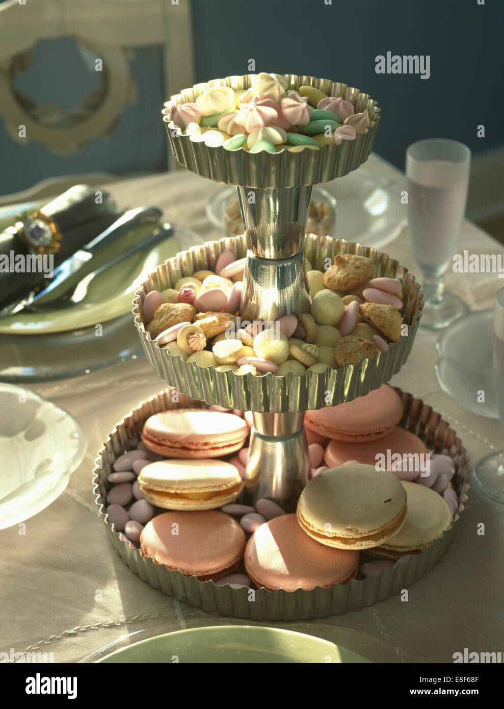 Close-up di confetti e amaretti su tre livelli di torta supporto costituito da metallo flan casi Foto Stock