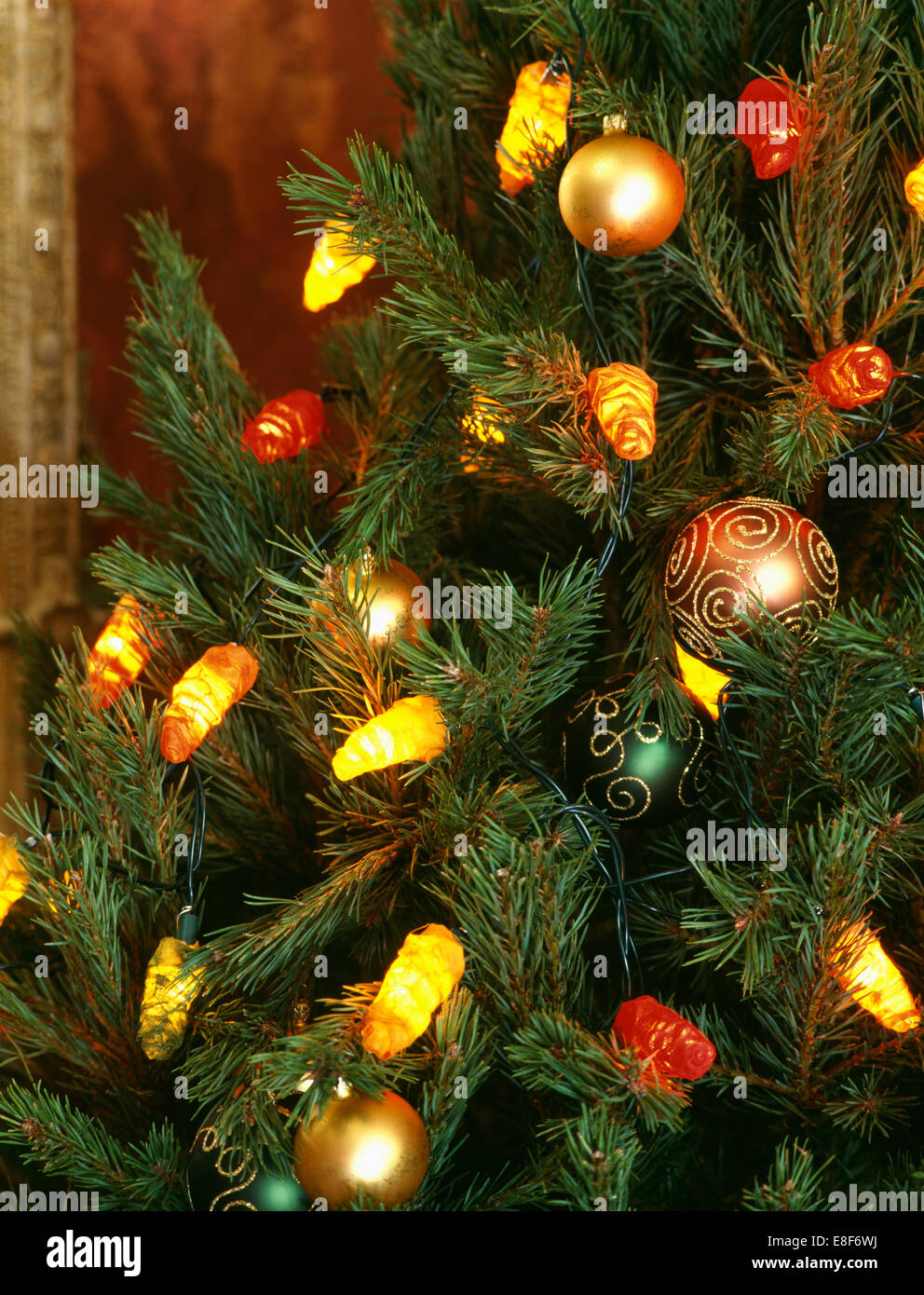 Close-up di albero di Natale con decorato a mano baubles di vetro colorato e luci di novità Foto Stock