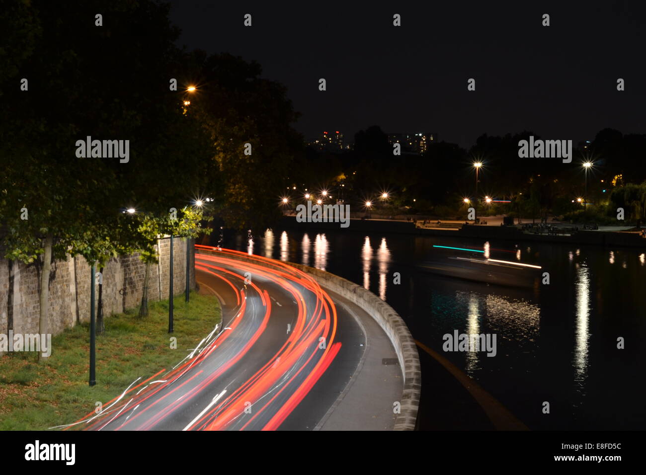 Seguire la luce. Pris sur le pont de Ile Saint Louis. Il traffico si muove attraverso Parigi a tarda notte in estate. Foto Stock