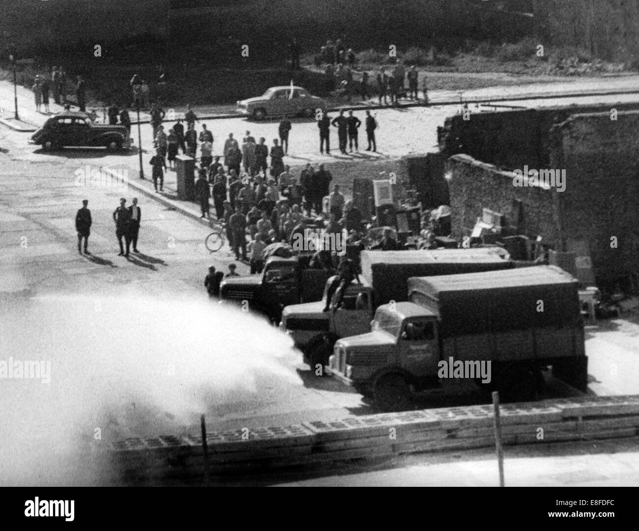 Camion e un cannone ad acqua in azione in una strada laterale del Bernauer Street sul lato di Berlino est il 24 settembre 1961. La gente di polizia della RDT ha iniziato con lo sfratto di confinanti con case in Bernauer Street e girato a guardare ad ovest i berlinesi, soprattutto gli operatori della fotocamera e i fotografi con gas lacrimogeni e acqua. Dal 13 agosto 1961, il giorno della costruzione del muro di Berlino, alla caduta del muro di Berlino del 9 novembre 1989, la Repubblica federale di Germania e della Repubblica democratica tedesca sono stati separati dalla cortina di ferro tra Occidente e Oriente. Foto Stock