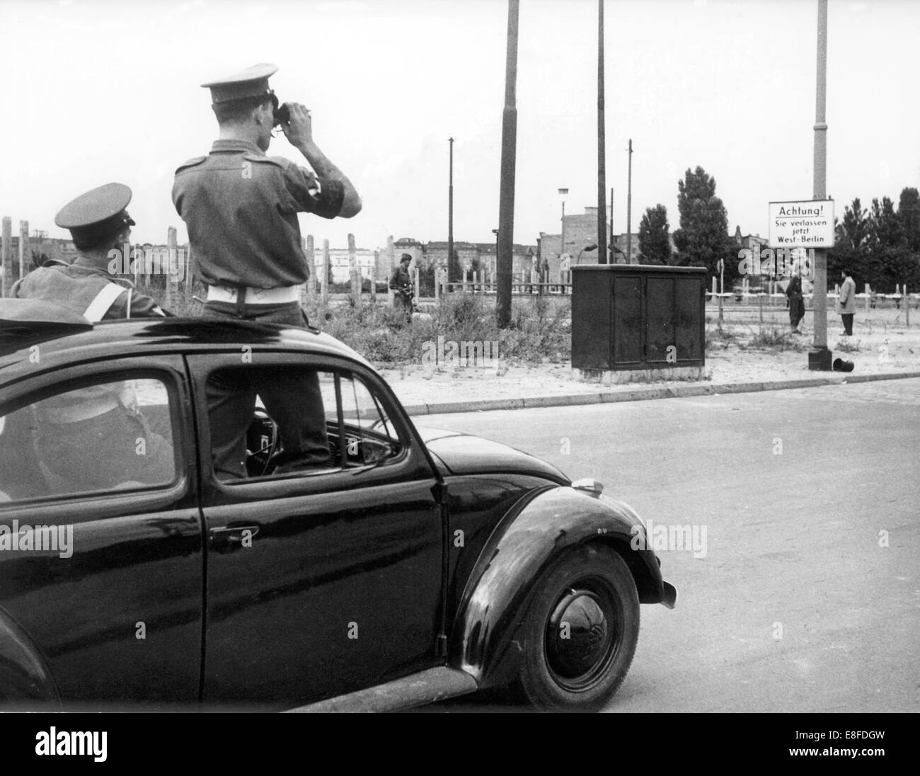 Due britannici della polizia militare uomini guardano la chiusa fuori confine del settore a Potsdamer Platz a Berlino il 13 agosto del 1961. Dal 13 agosto del 1961, il giorno della costruzione del muro, fino alla caduta del muro di Berlino il 9 novembre nel 1989, il Repulic federale di Germania e della Repubblica democratica tedesca sono state separate dalla cortina di ferro tra Occidente e Oriente. Foto Stock