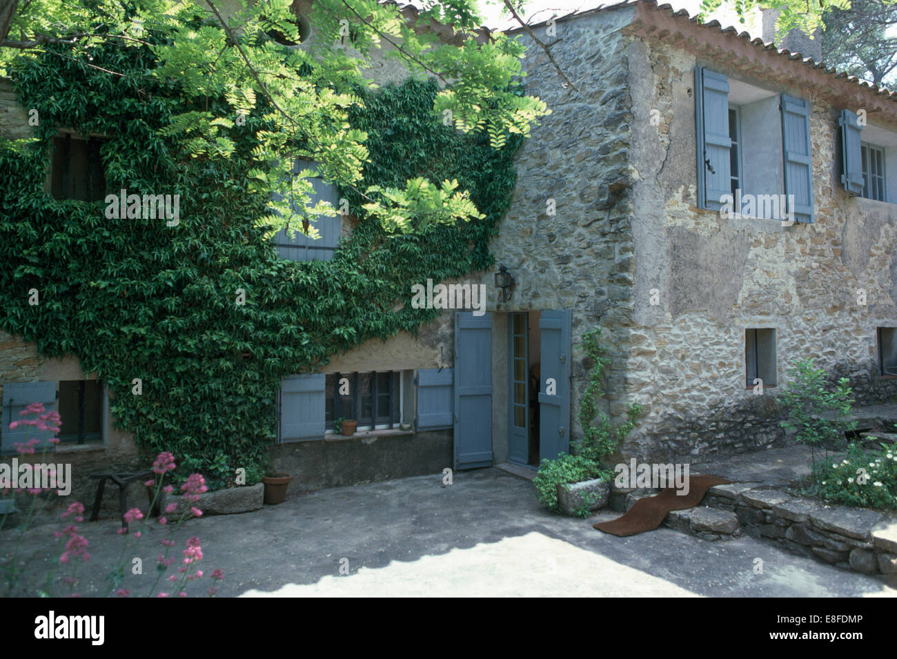 Persiane blu su porte e finestre di una vecchia casa di pietra nel sud della Francia Foto Stock