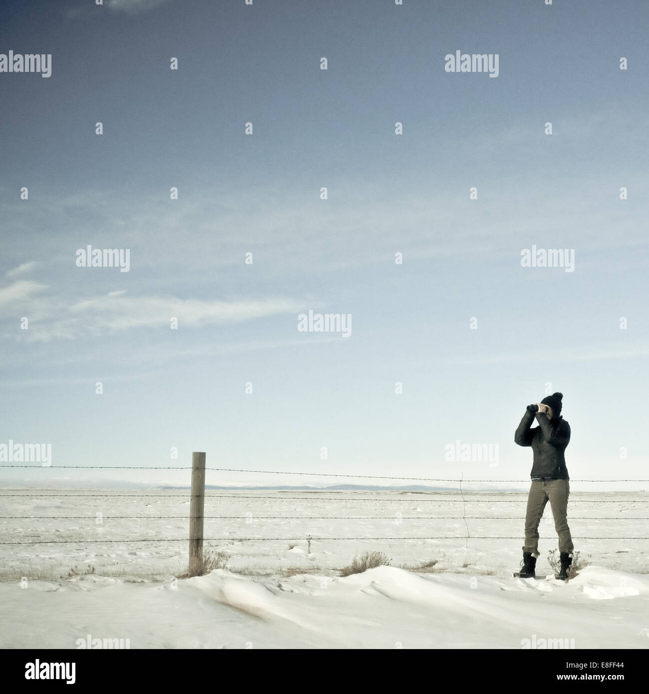 Donna che guarda attraverso binocoli in inverno, Wyoming, Stati Uniti Foto Stock
