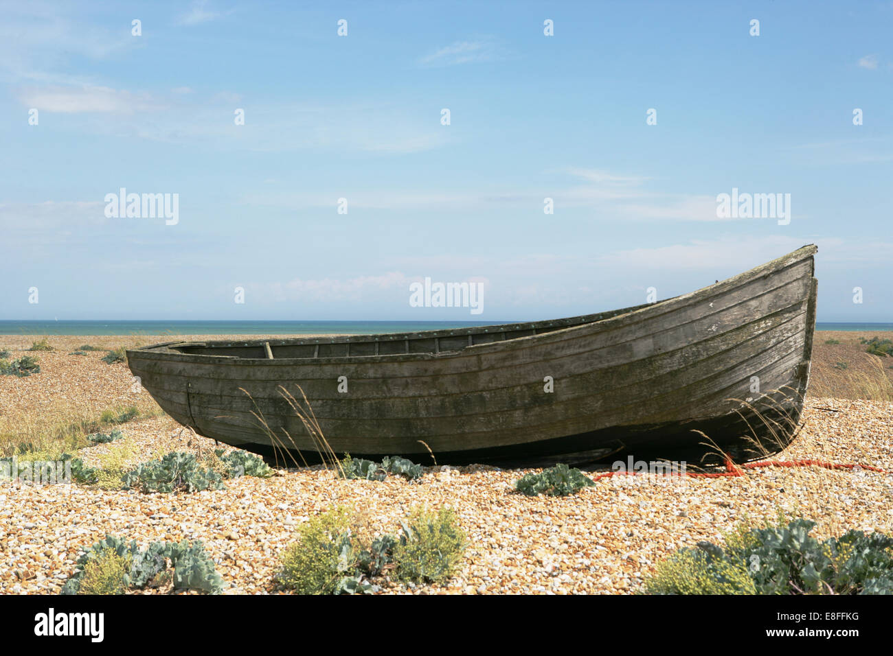 Vecchia barca a remi sulla spiaggia di ciottoli, Dungeness, Kent, Inghilterra, Regno Unito Foto Stock