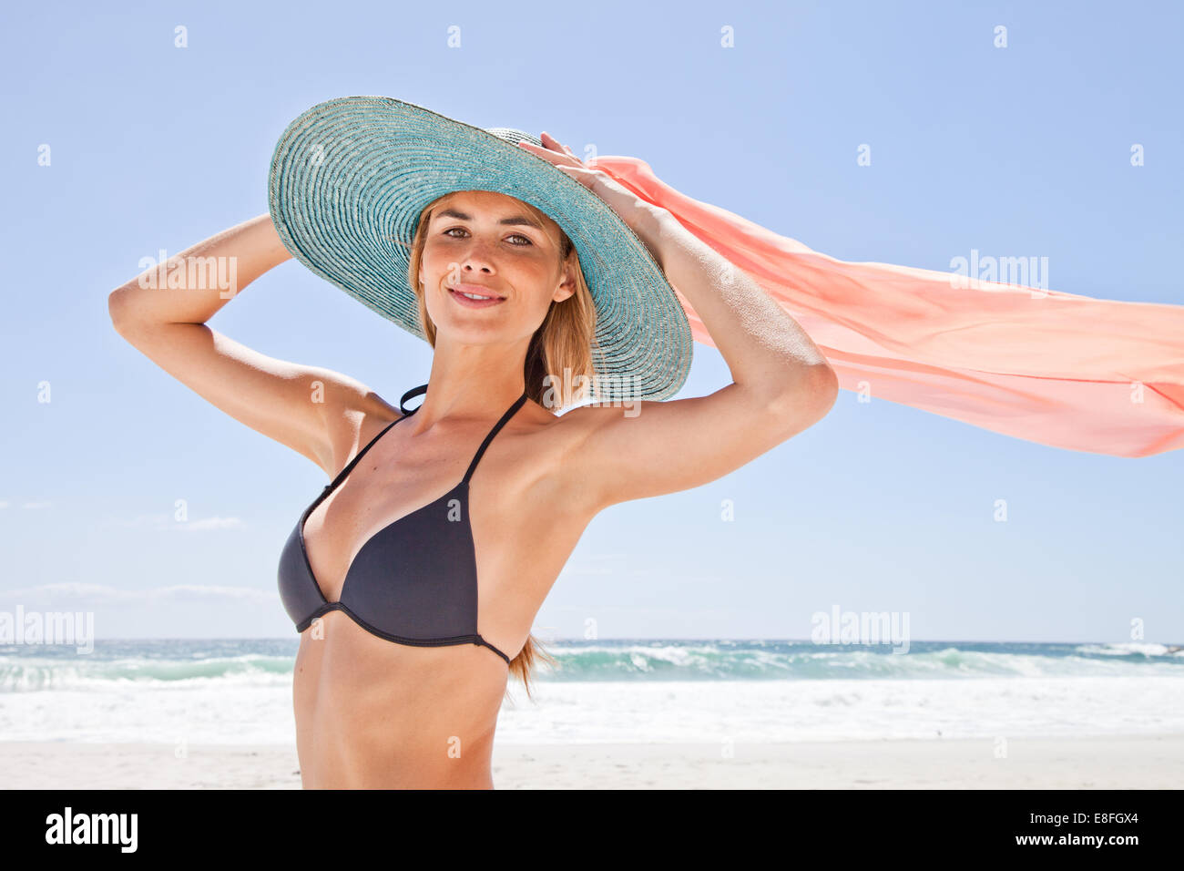 Donna in bikini che tiene sopra la testa una sciarpa di seta, Città del Capo, Capo Occidentale, Sudafrica Foto Stock