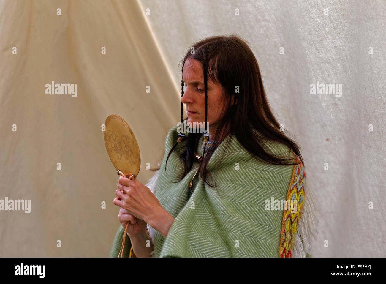 Donna vestita come un inglese sembra in un lucido in lega di rame specchio decorato in modo simile al Trelan Bahow / St Keverne specchio Foto Stock