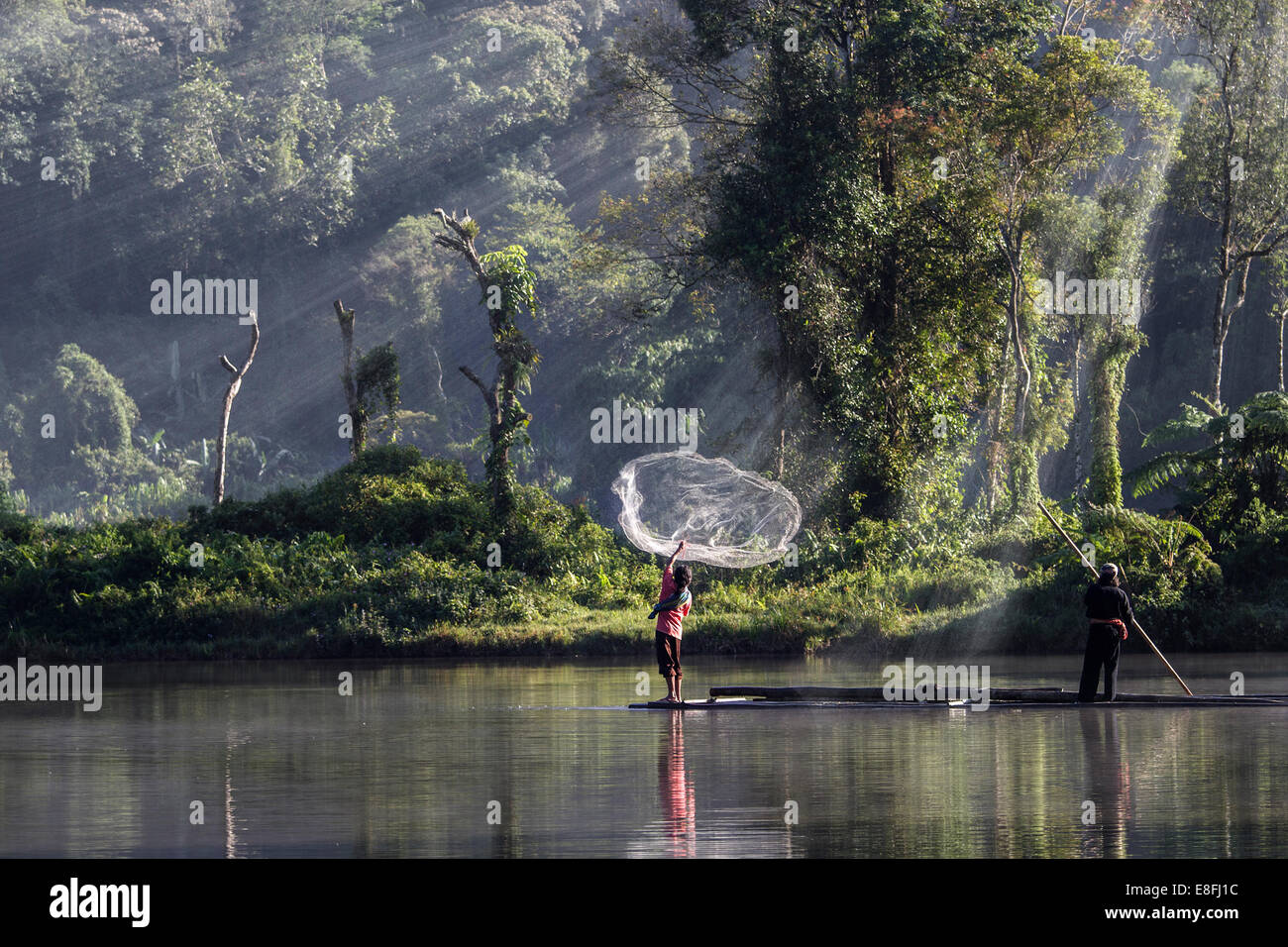 Indonesia, West Java, Karawang, Situ Gunung, uomo gettando rete da pesca in acqua Foto Stock