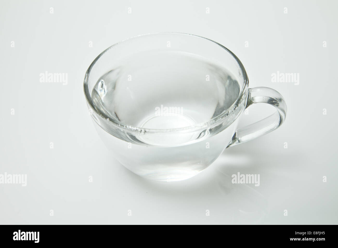 Tazza da tè in vetro riempita con acqua calda su sfondo bianco Foto Stock