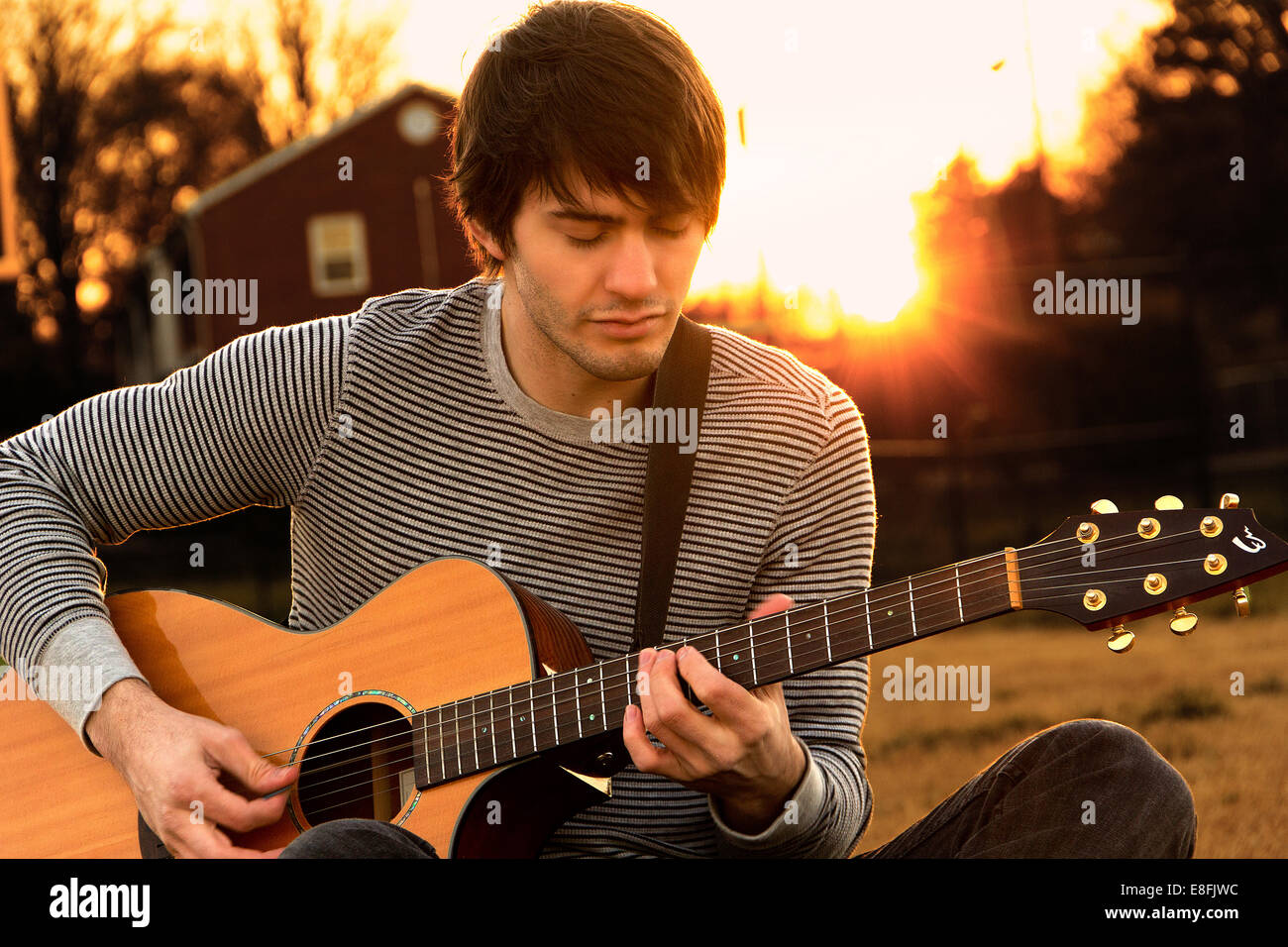 Giovane uomo a suonare la chitarra Foto Stock