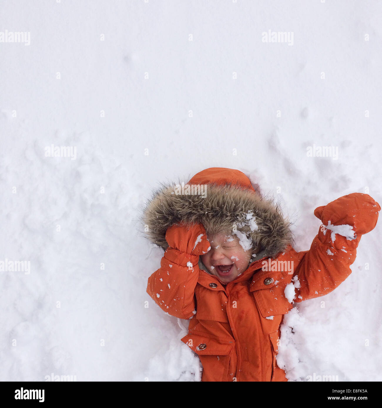 Felice ragazzo che giace sulla neve, Lake Tahoe, California, USA Foto Stock