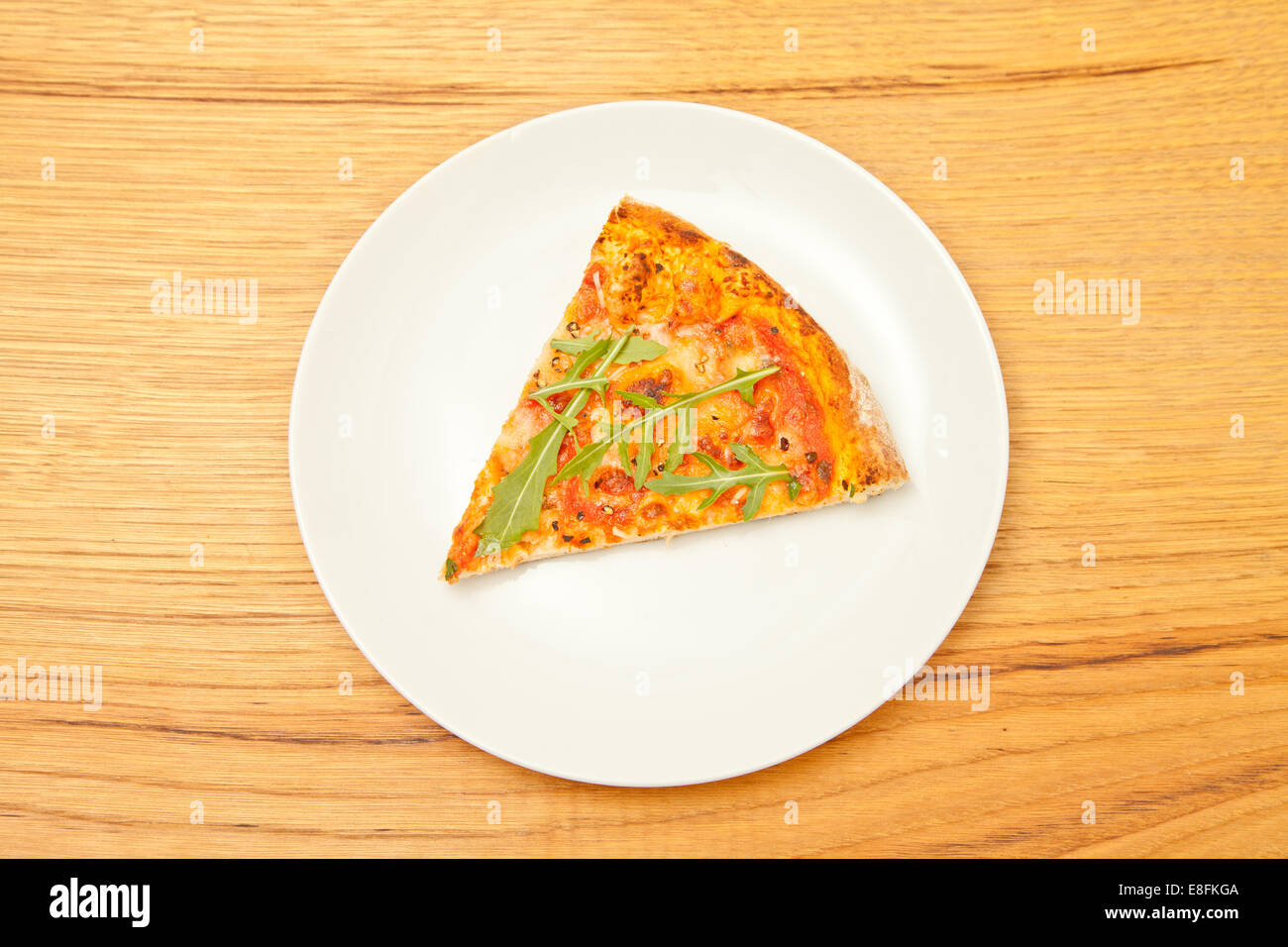 Fetta di formaggio e pomodoro Pizza con rucola su un piatto Foto Stock