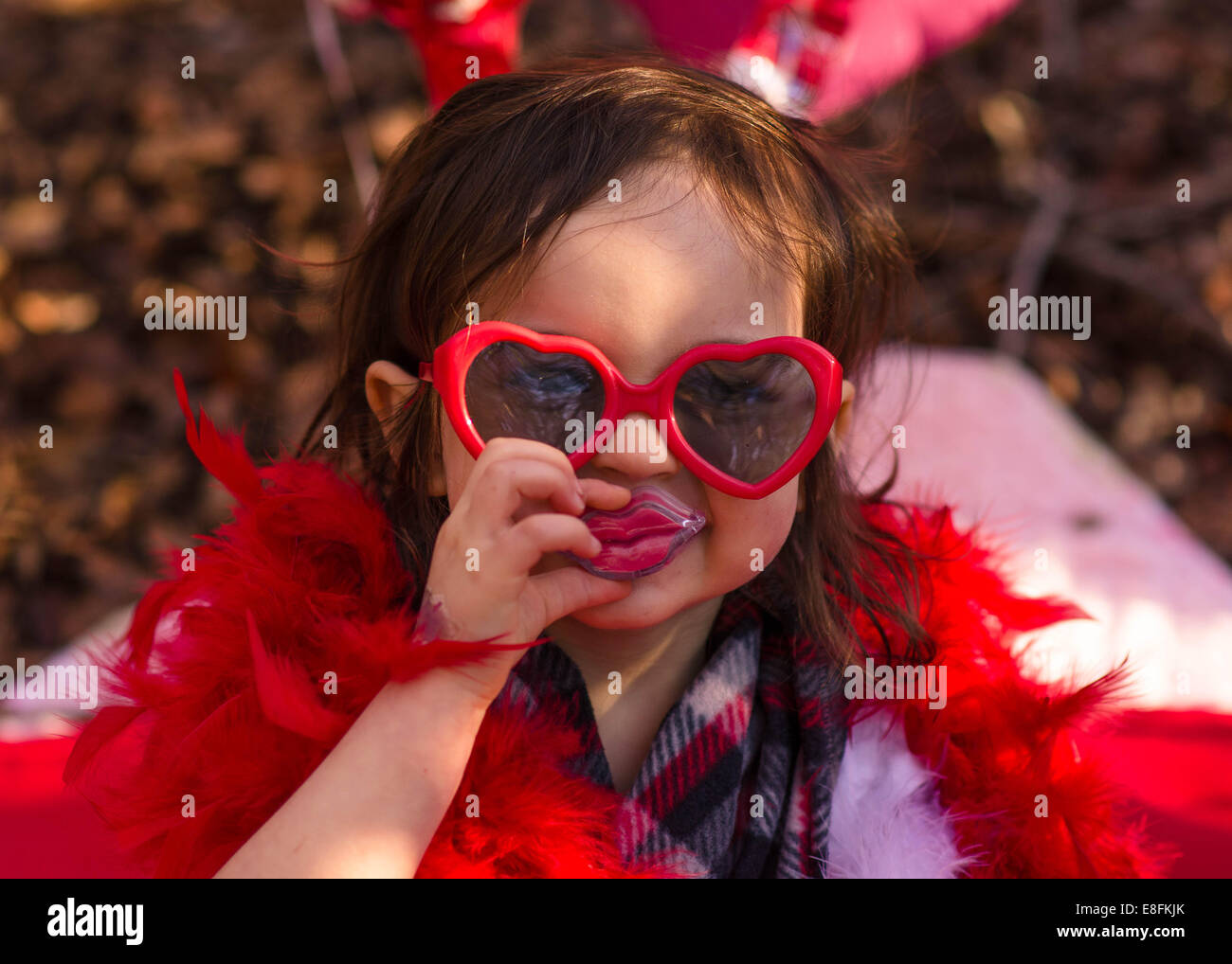 Ritratto di una ragazza che indossa occhiali da sole a forma di cuore e labbra giocattolo, Texas, USA Foto Stock
