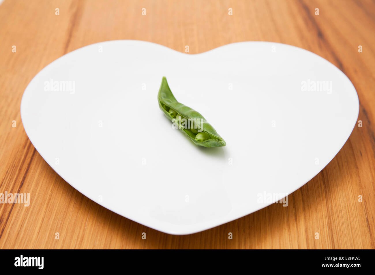 Primo piano di una cialda di piselli sulla piastra a forma di cuore Foto Stock