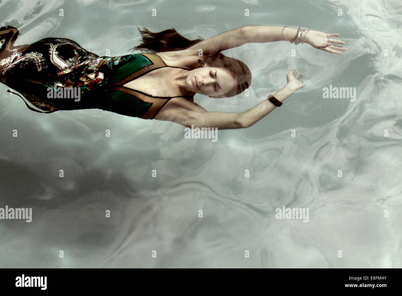 Vista dall'alto di una donna in un abito che nuota sott'acqua Foto Stock