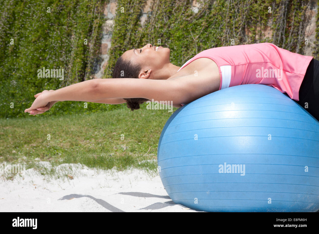 Donna che si stretona su una palla di fitness, Città del Capo, Capo Occidentale, Sud Africa Foto Stock