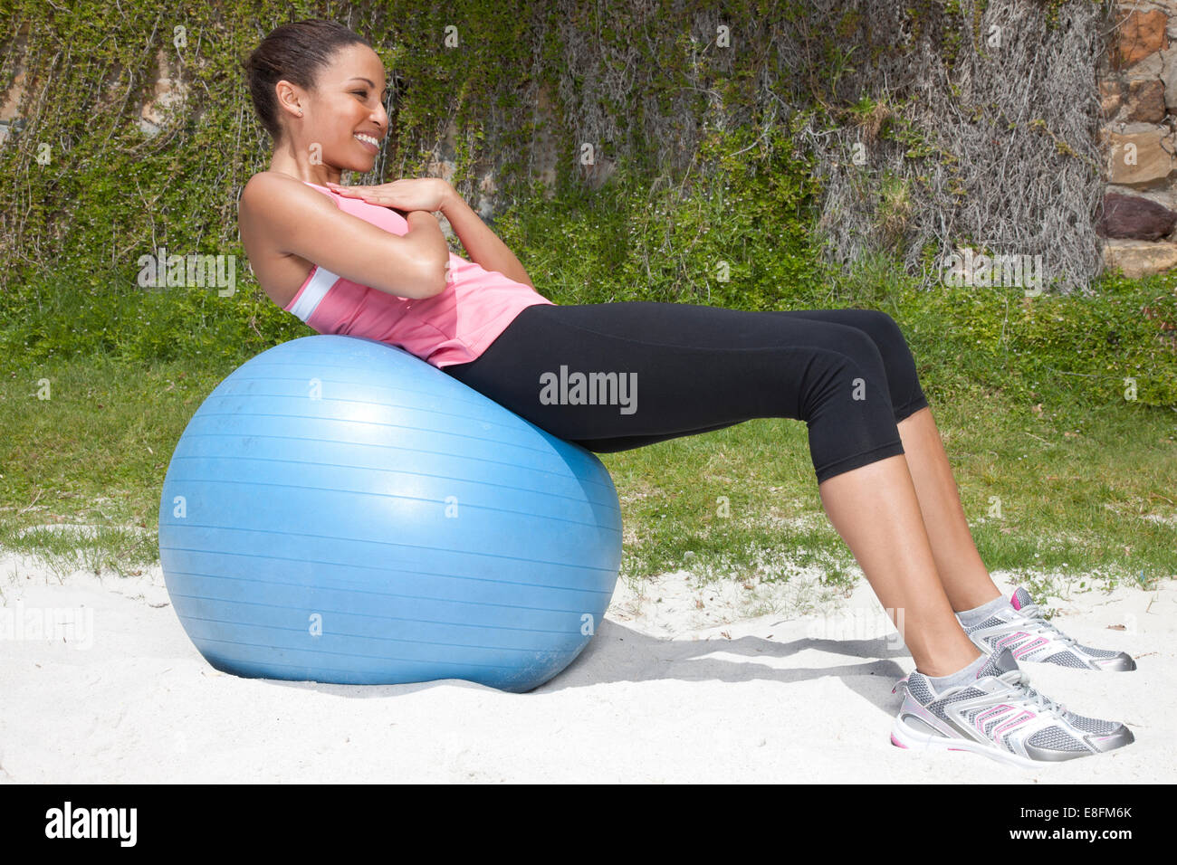Donna che si siede su una palla di fitness, Città del Capo, Capo Occidentale, Sud Africa Foto Stock