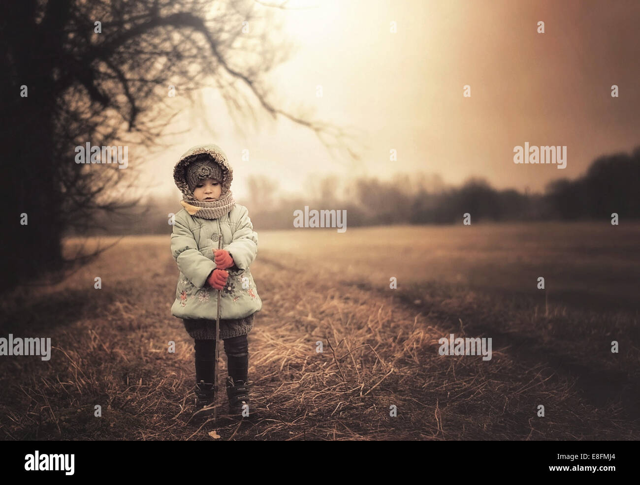 La Polonia, ragazza di indossare abiti caldi in piedi sul campo Foto Stock